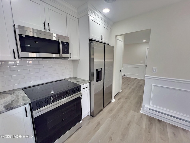 kitchen featuring light stone counters, light hardwood / wood-style flooring, white cabinets, and appliances with stainless steel finishes