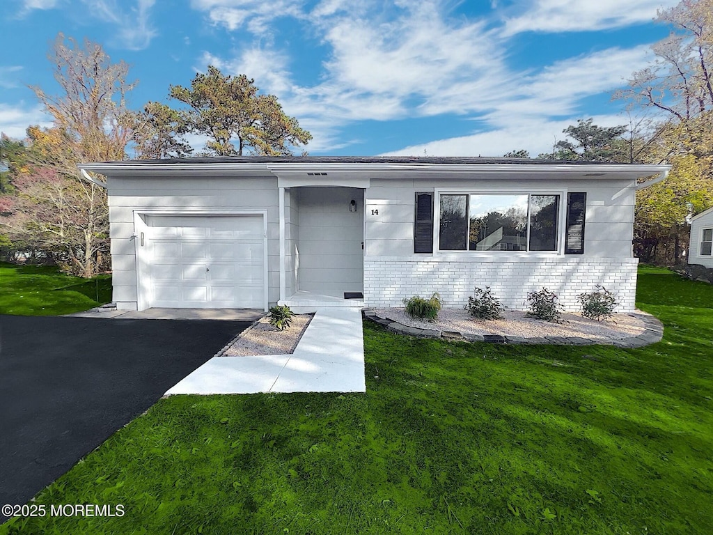 ranch-style house featuring a front yard and a garage