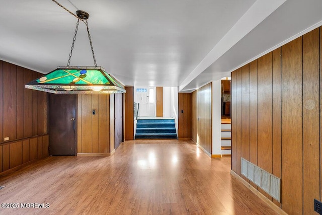 unfurnished dining area with wood walls and hardwood / wood-style floors