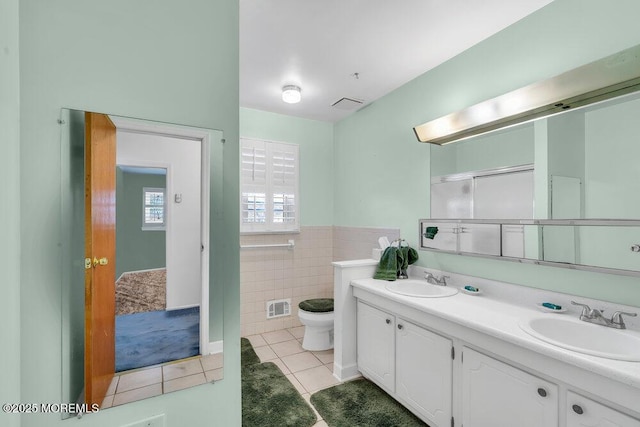 bathroom with tile patterned flooring, vanity, tile walls, and toilet