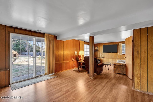 living room featuring light hardwood / wood-style floors and wooden walls