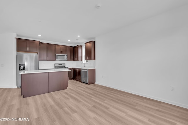 kitchen featuring a kitchen island, sink, light hardwood / wood-style floors, and stainless steel appliances