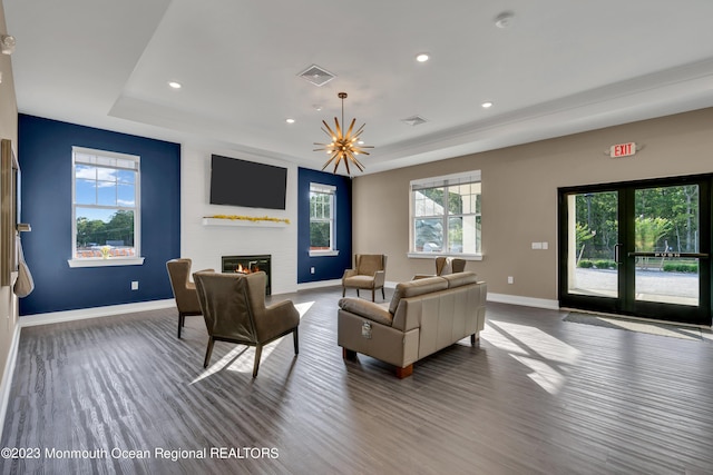 living room featuring plenty of natural light, french doors, a fireplace, and a tray ceiling