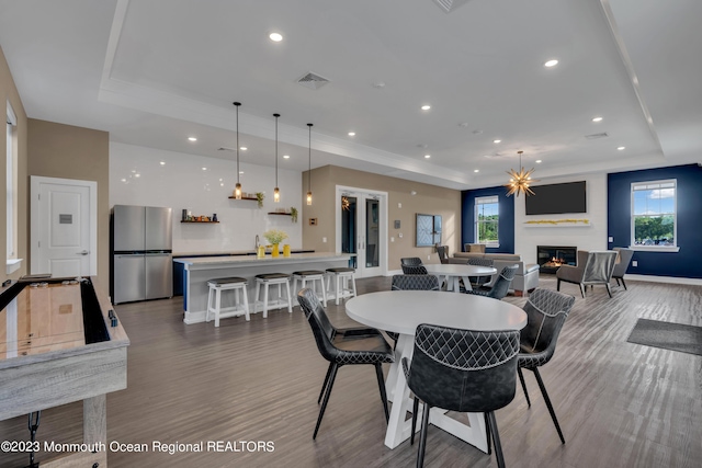 dining area featuring a raised ceiling and hardwood / wood-style flooring