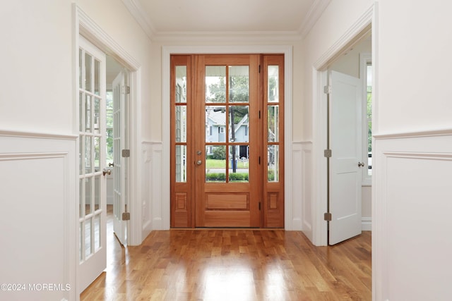 doorway with light wood-type flooring and ornamental molding