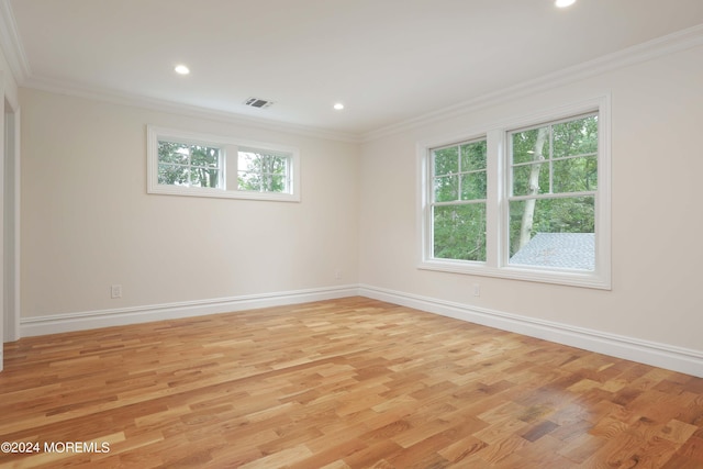 empty room with ornamental molding and light hardwood / wood-style flooring