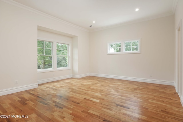 spare room featuring crown molding and light wood-type flooring