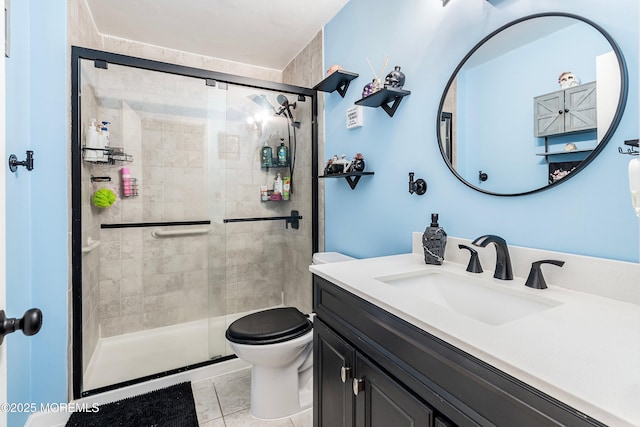 bathroom featuring toilet, tile patterned floors, a shower with door, and vanity