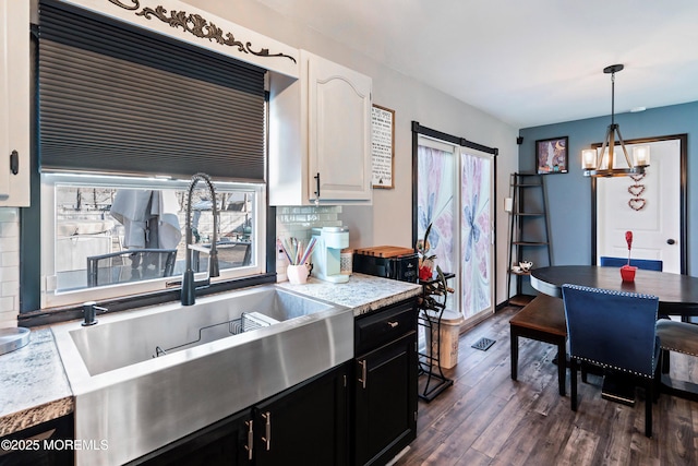 kitchen featuring dark wood-type flooring, white cabinetry, tasteful backsplash, sink, and hanging light fixtures