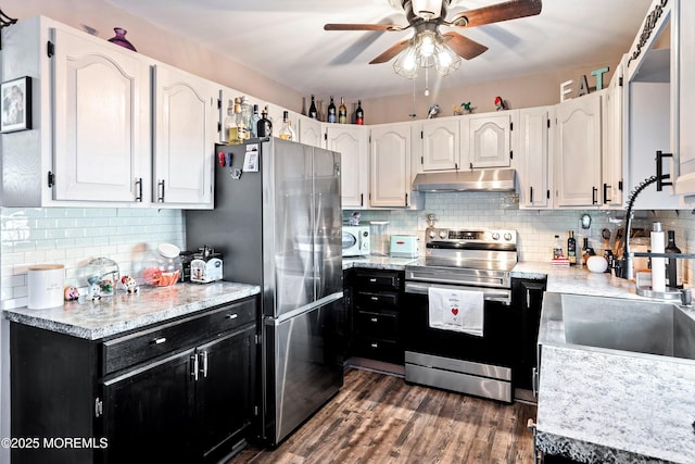 kitchen with decorative backsplash, dark hardwood / wood-style flooring, stainless steel appliances, and white cabinetry