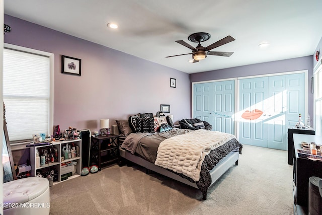 carpeted bedroom with ceiling fan and multiple closets