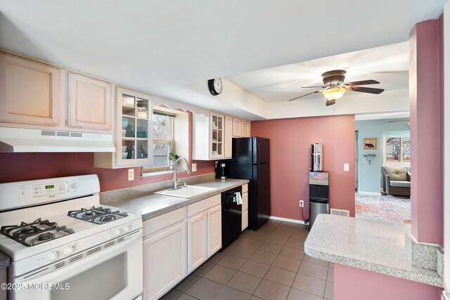 kitchen with tile patterned floors, a tray ceiling, ceiling fan, sink, and black appliances