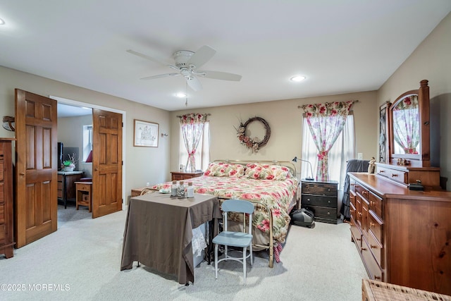 carpeted bedroom featuring ceiling fan and multiple windows