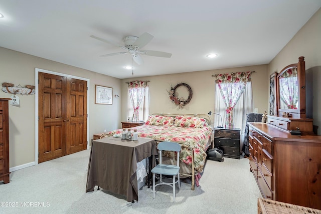 bedroom with ceiling fan, a closet, and light colored carpet