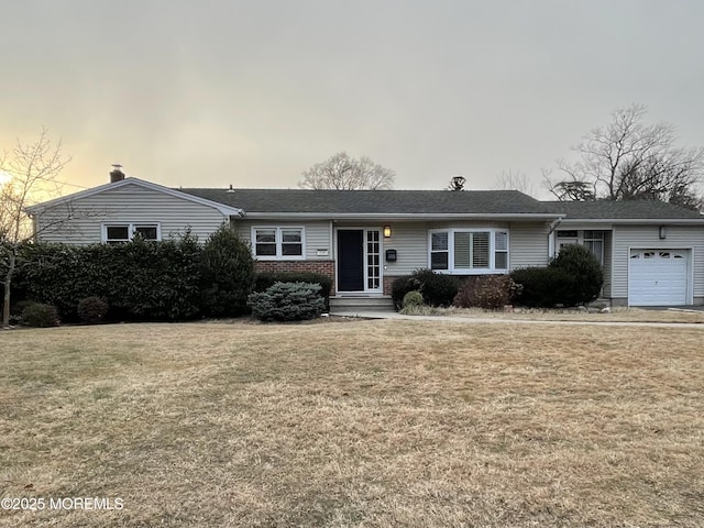 single story home with a garage and a yard