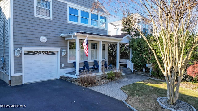 view of front facade featuring covered porch and a garage