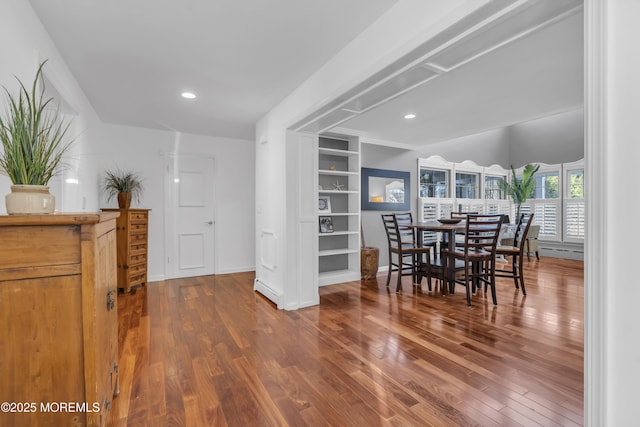 dining room with hardwood / wood-style floors and built in features