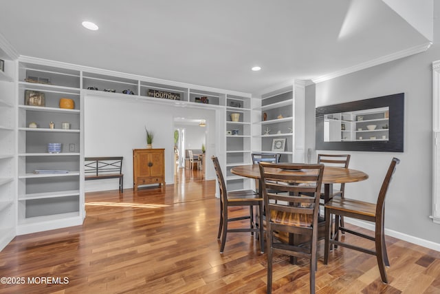 dining area featuring crown molding, hardwood / wood-style flooring, and built in features