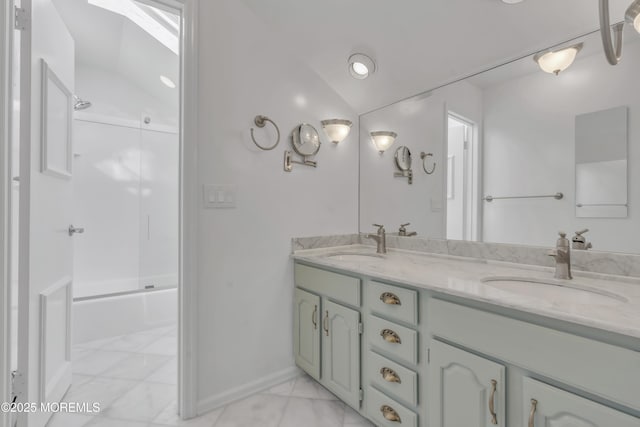 bathroom with combined bath / shower with glass door, vaulted ceiling, and vanity