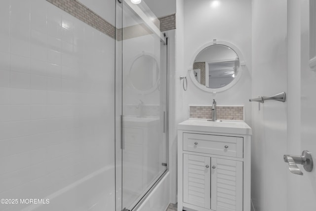 bathroom featuring bath / shower combo with glass door and vanity