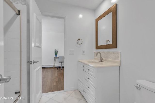 bathroom featuring tile patterned flooring, toilet, backsplash, vanity, and baseboard heating