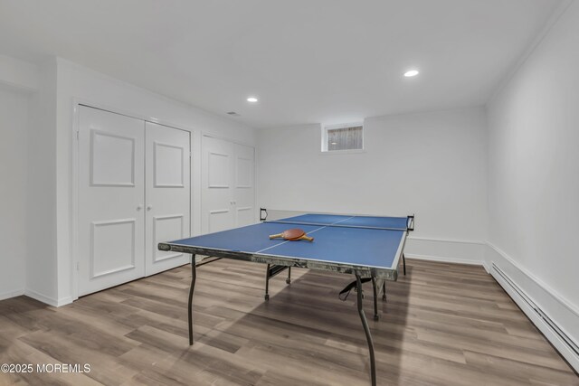 rec room featuring a baseboard radiator and light hardwood / wood-style floors