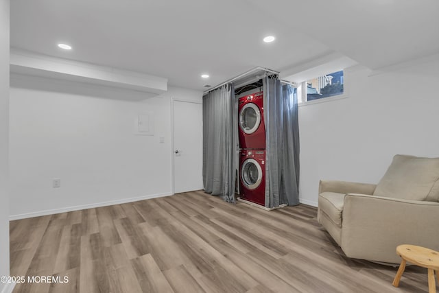 interior space featuring stacked washer / drying machine and light hardwood / wood-style floors