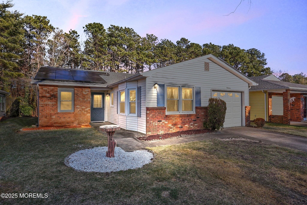 view of front facade with solar panels, a garage, and a yard