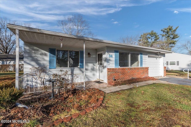 view of front of home with a porch, a front yard, and a garage