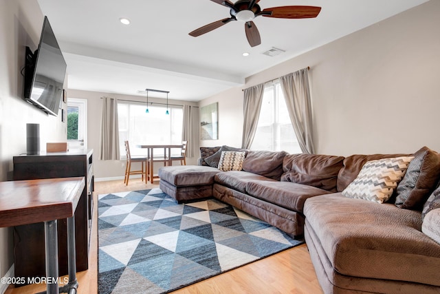 living room featuring ceiling fan, a wealth of natural light, and light hardwood / wood-style flooring