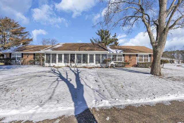 snow covered property with a sunroom