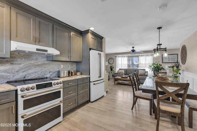 kitchen featuring high end range, light stone countertops, tasteful backsplash, ceiling fan, and white fridge