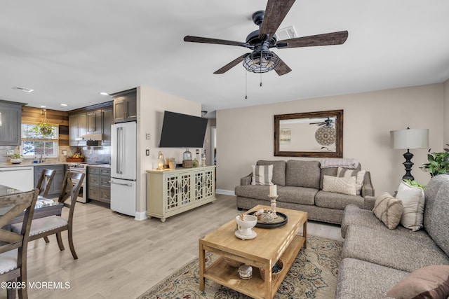 living room featuring light wood-type flooring and ceiling fan