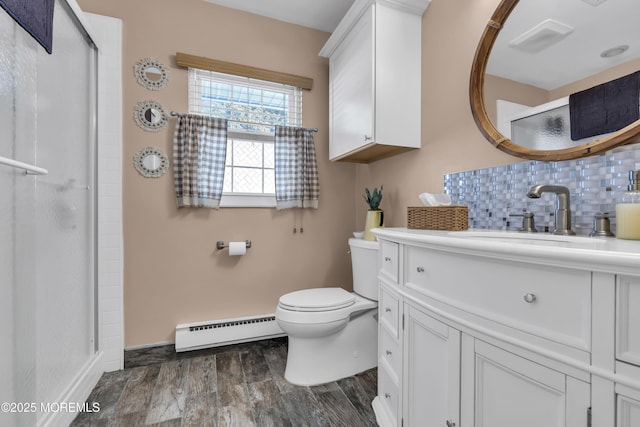 bathroom with hardwood / wood-style floors, vanity, backsplash, toilet, and baseboard heating