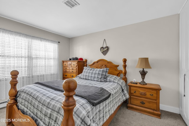 carpeted bedroom featuring a baseboard heating unit