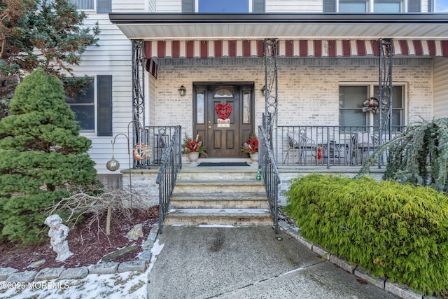 view of exterior entry with covered porch