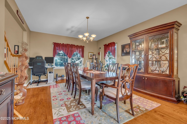 dining room with light hardwood / wood-style flooring and a chandelier