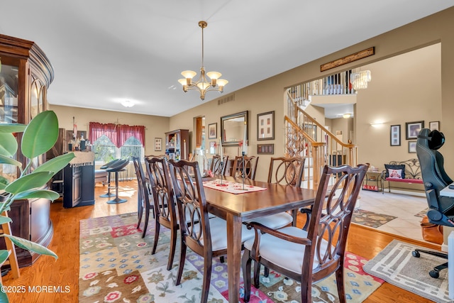 dining space with a notable chandelier and light hardwood / wood-style floors