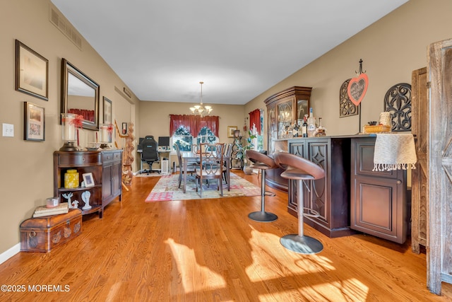 dining area featuring a notable chandelier and light hardwood / wood-style flooring