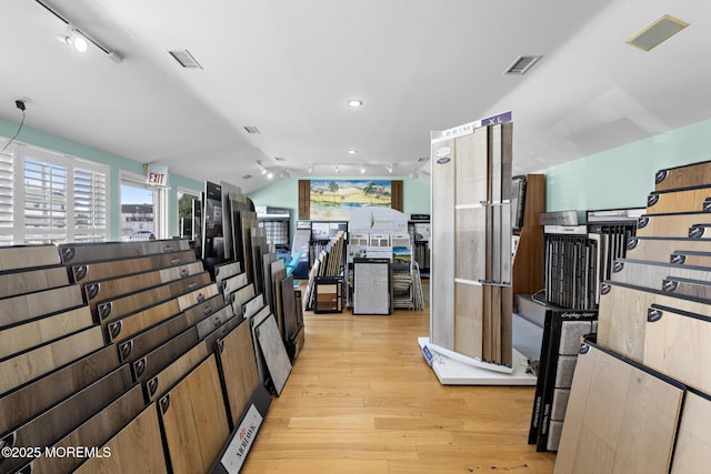 hall with light hardwood / wood-style flooring and lofted ceiling