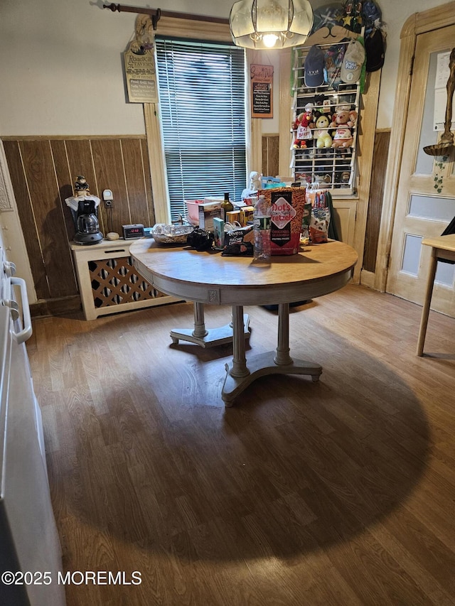 dining room featuring hardwood / wood-style floors and wooden walls