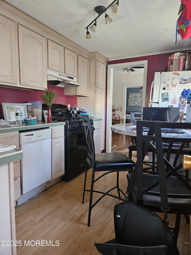 kitchen with ceiling fan, track lighting, cream cabinetry, white appliances, and light wood-type flooring