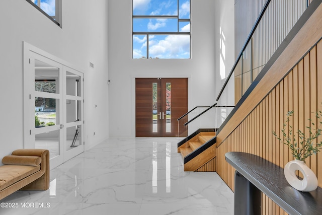 entryway with a towering ceiling and french doors