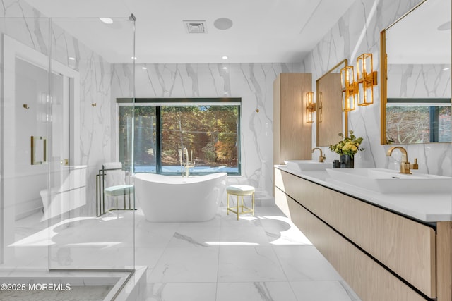 bathroom with vanity and shower with separate bathtub