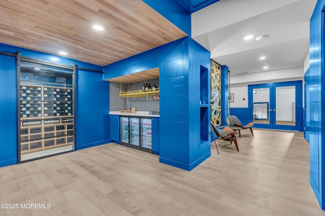 bar featuring hardwood / wood-style flooring, a barn door, and wood ceiling