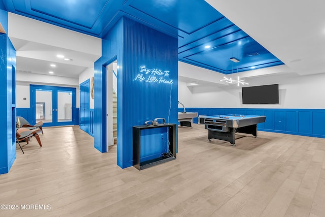 playroom with a tray ceiling, french doors, light hardwood / wood-style floors, and billiards