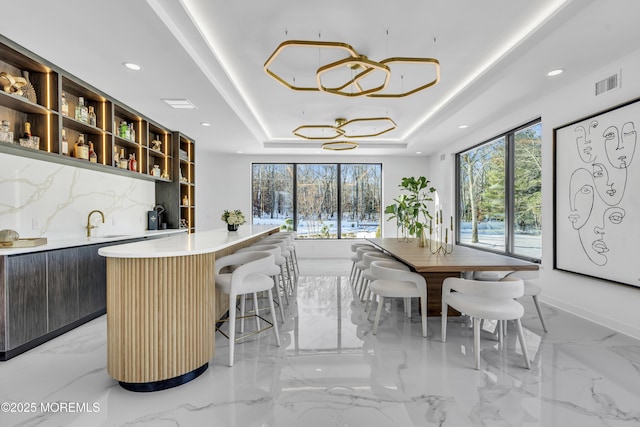 interior space with a tray ceiling and sink