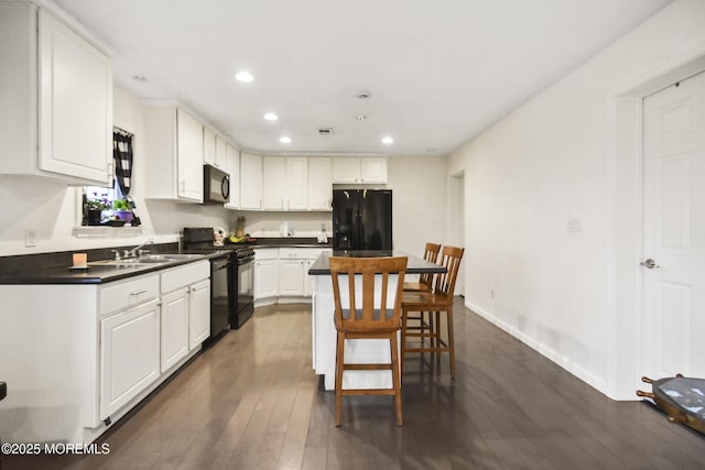 kitchen featuring white cabinetry, dark wood-type flooring, black appliances, and sink