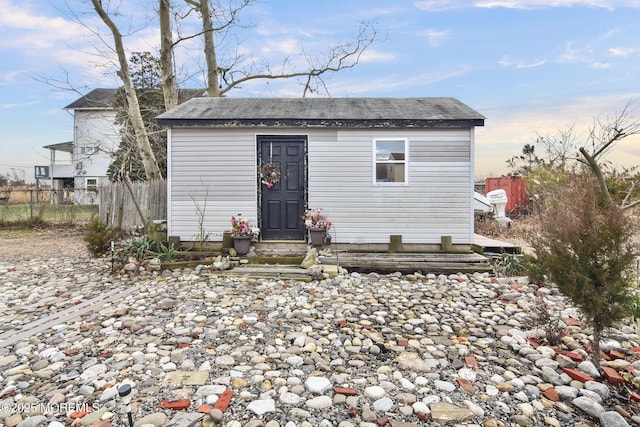 back house at dusk with a storage shed