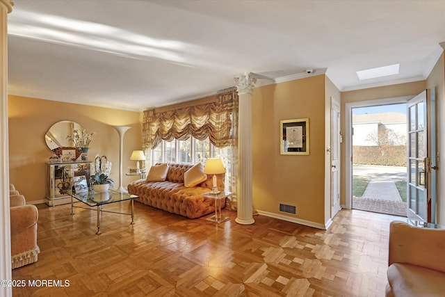 living room featuring ornate columns, a wealth of natural light, parquet floors, and a skylight